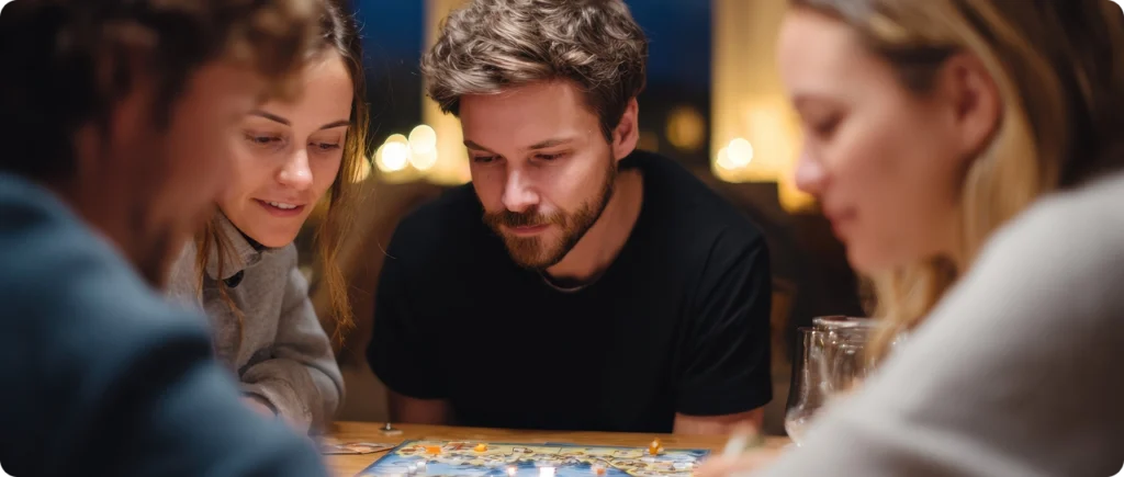 Um grupo de amigos joga concentradamente um jogo de tabuleiro à volta de uma mesa, sob uma iluminação acolhedora à noite